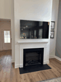 Flush-mount TV over a fireplace, no cables showing.